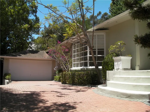 a view of a house with a yard and potted plants