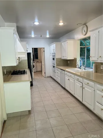 a kitchen with a sink a stove and cabinets