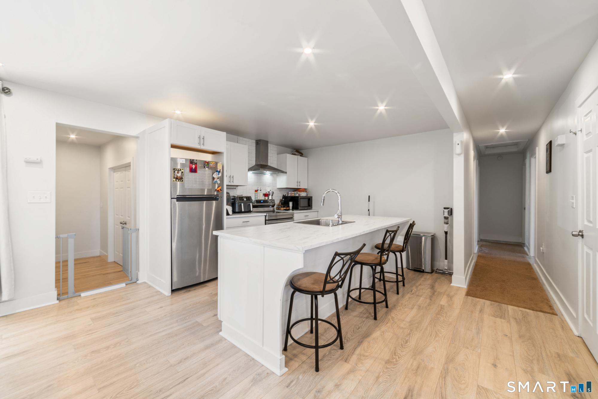 327 Lakeside Boulevard West Waterbury, CT 06708 - Photo 3 of 29 a kitchen with stainless steel appliances a dining table chairs and wooden floor