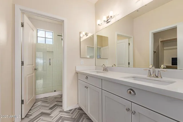 a bathroom with a double vanity sink mirror and shower