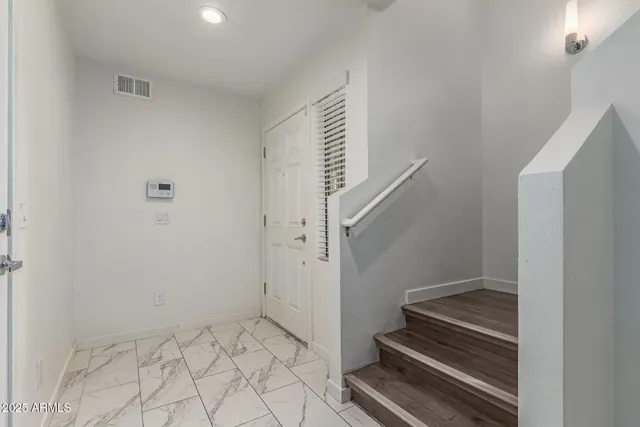 a view of entryway with white walls and tiles
