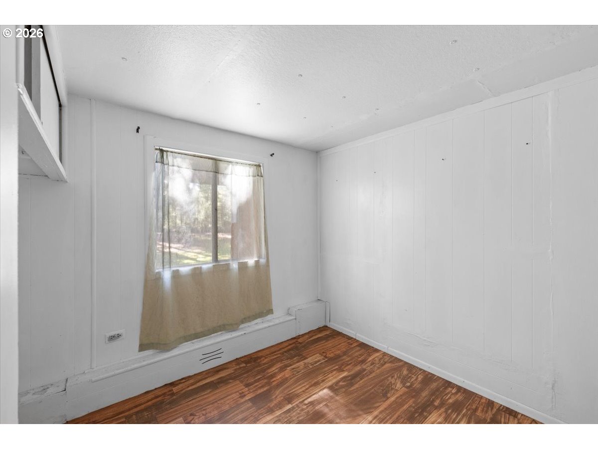 280 Cobalt Drive O'Brien, OR 97523 - Photo 16 of 27 an empty room with wooden floor and windows