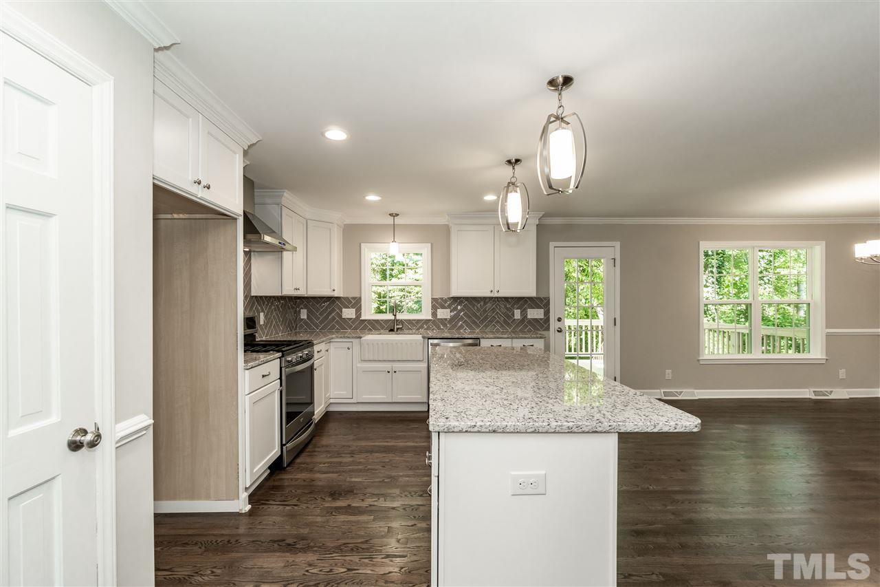 7204 Grist Mill Road Raleigh, NC 27615 - Photo 11 of 30 a kitchen with stainless steel appliances granite countertop a sink refrigerator and cabinets