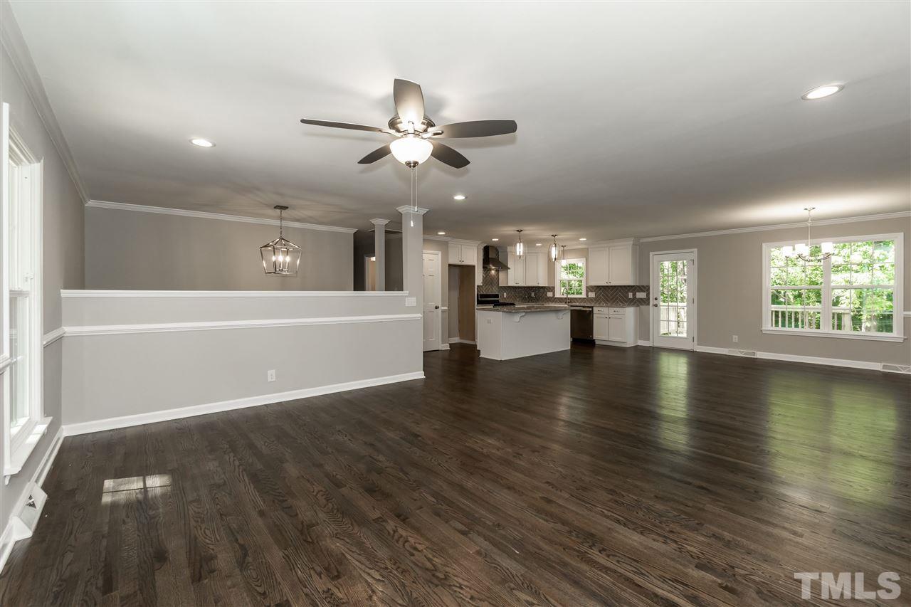 7204 Grist Mill Road Raleigh, NC 27615 - Photo 12 of 30 an empty room with wooden floor chandelier fan and windows
