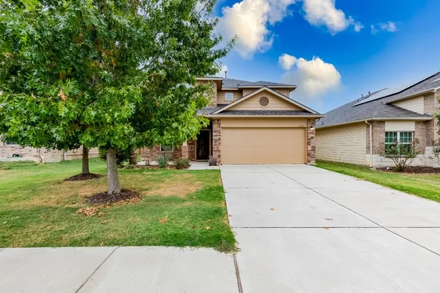 a front view of a house with a yard and garage