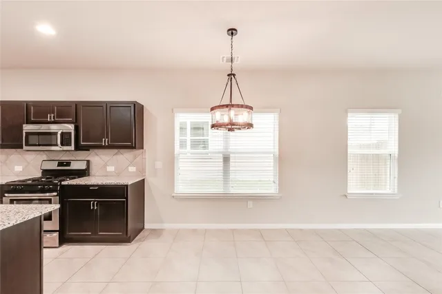 a kitchen with stainless steel appliances granite countertop a stove and a microwave