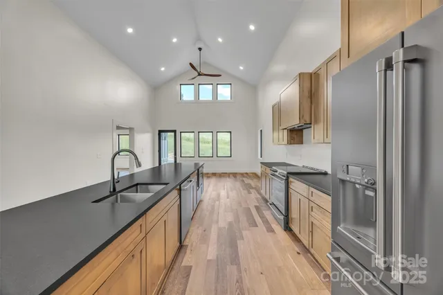 a kitchen with granite countertop a sink a counter space appliances and cabinets