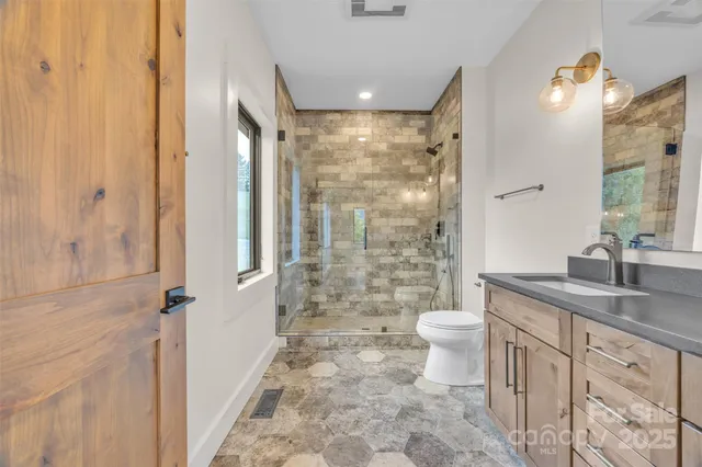 a bathroom with a granite countertop sink toilet and shower