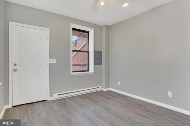 an empty room with wooden floor and windows