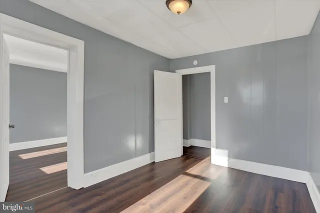an empty room with wooden floor and closet