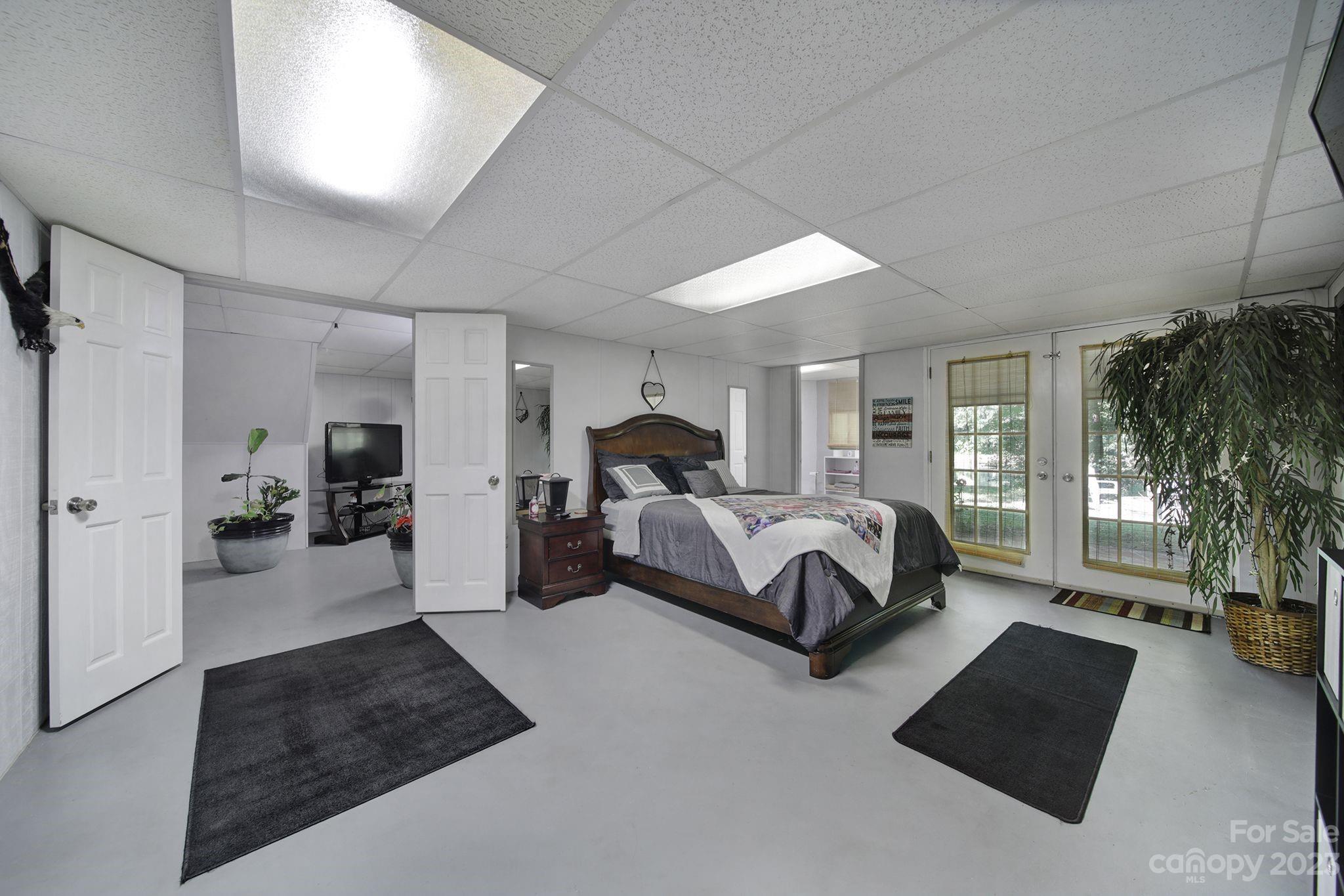 332 Boggs Road Thomasville, NC 27360 - Photo 29 of 41 a spacious bedroom with a bed a couch and a potted plant