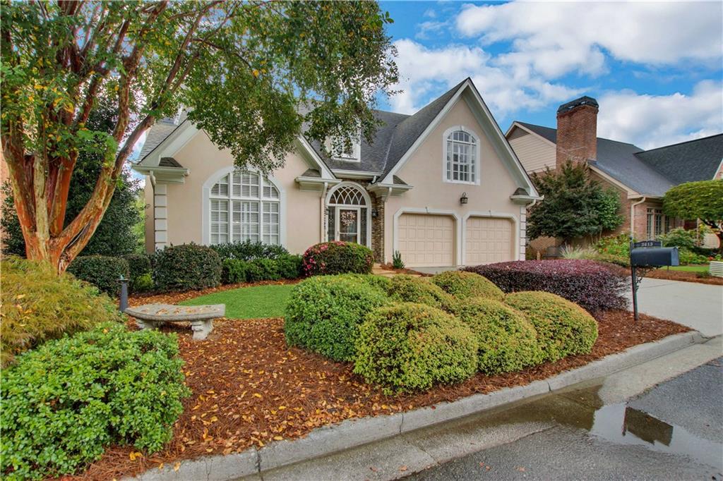 a front view of a house with a yard and potted plants