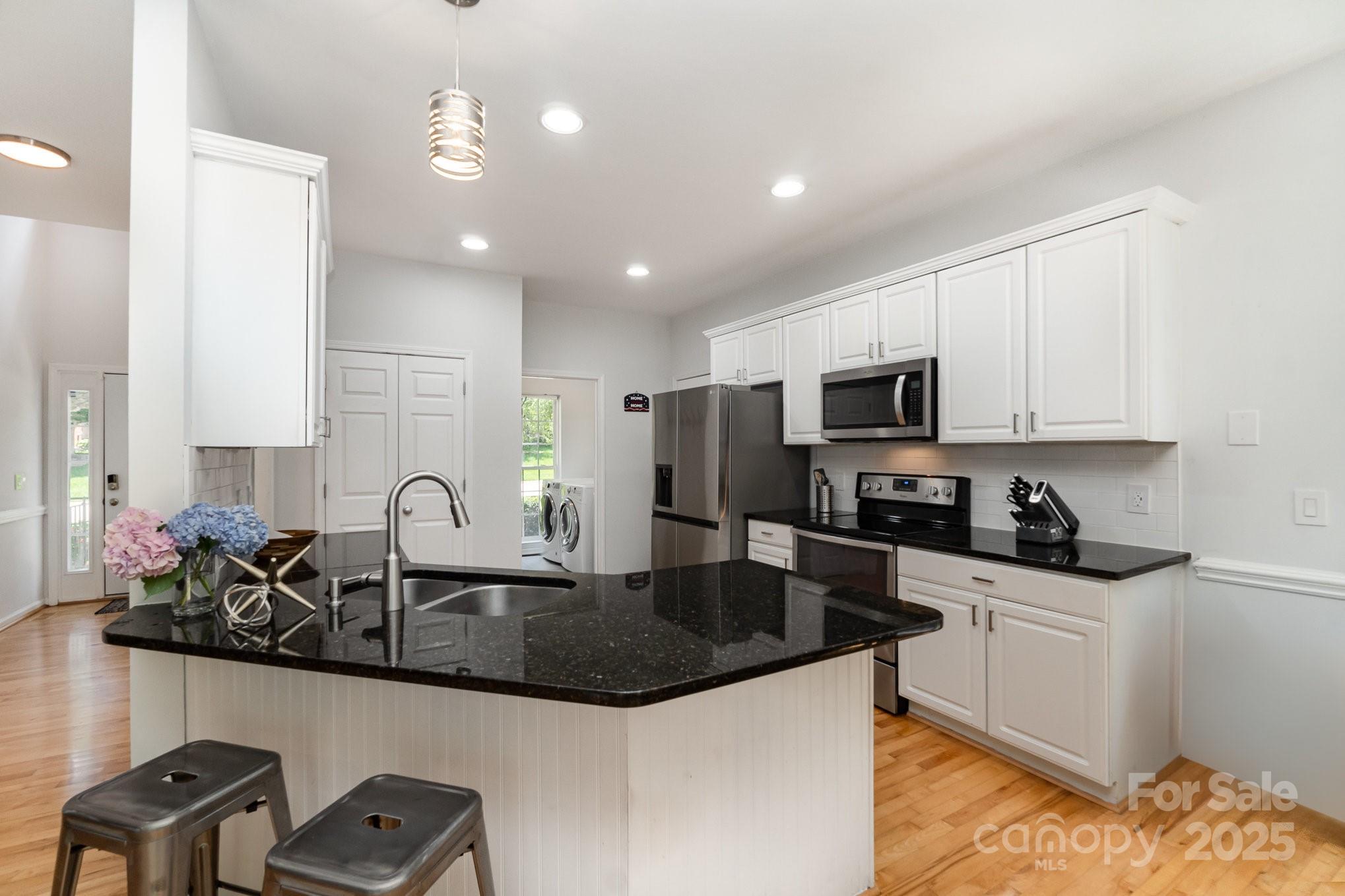 11624 Crossroads Place Concord, NC 28025 - Photo 14 of 45 a kitchen with granite countertop a sink a stove and cabinets