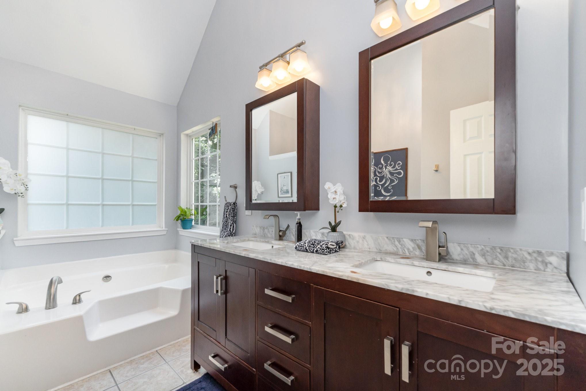 11624 Crossroads Place Concord, NC 28025 - Photo 23 of 45 a bathroom with a tub a double vanity sink and mirror