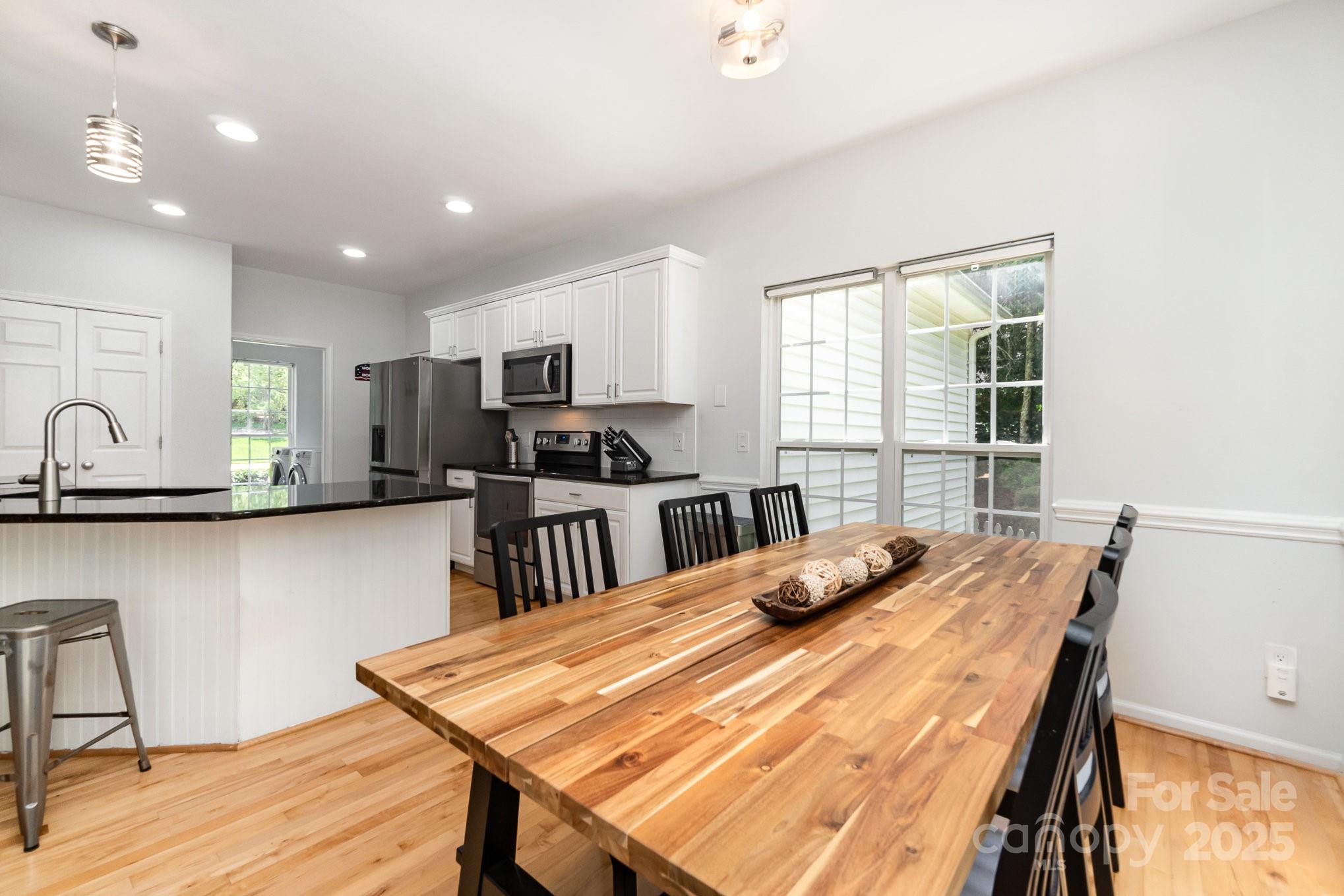 11624 Crossroads Place Concord, NC 28025 - Photo 10 of 45 a kitchen with granite countertop a stove a sink a dining table and chairs