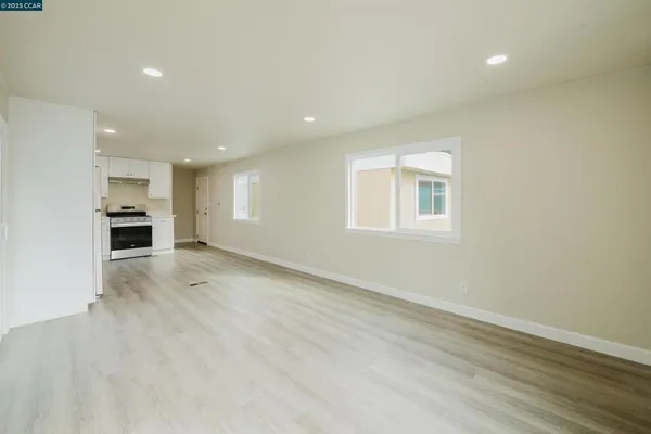 an empty room with a kitchen and a window