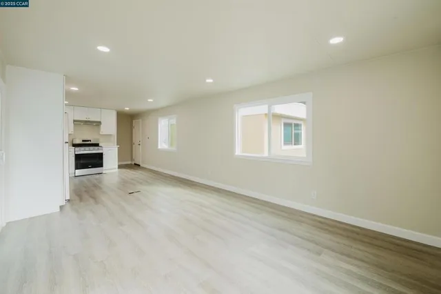 an empty room with a kitchen and a window