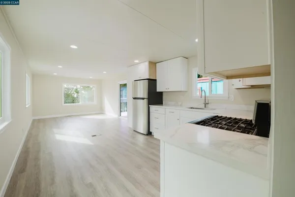 a kitchen with stainless steel appliances kitchen island granite countertop a refrigerator and a stove top oven