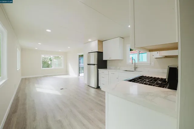 a kitchen with stainless steel appliances kitchen island granite countertop a refrigerator and a stove top oven