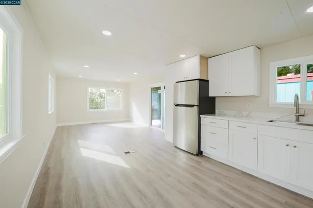 a view of a kitchen with a sink dishwasher and a refrigerator