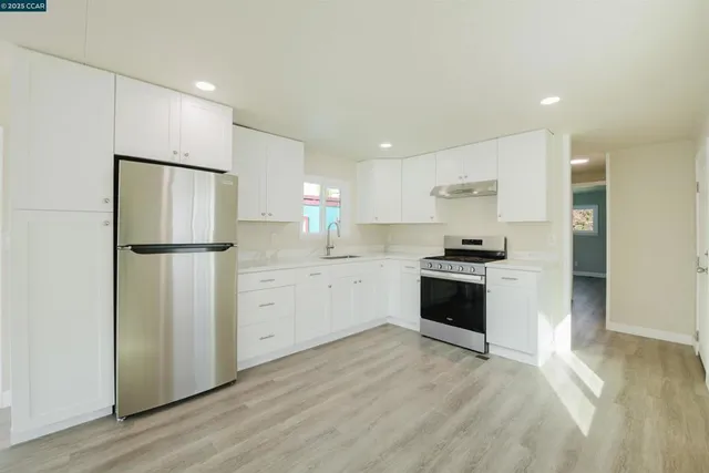 a kitchen with white cabinets and stainless steel appliances