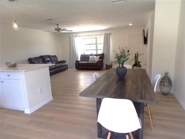 a living room with furniture a window and potted plants