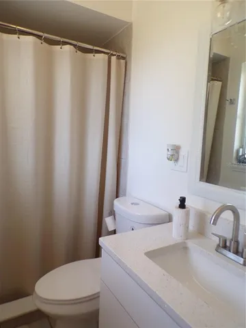 a bathroom with a sink mirror vanity and toilet