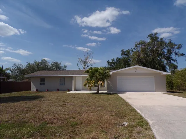 a front view of house with yard and trees around