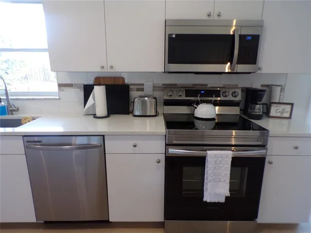 a kitchen with stainless steel appliances granite countertop a stove and a microwave