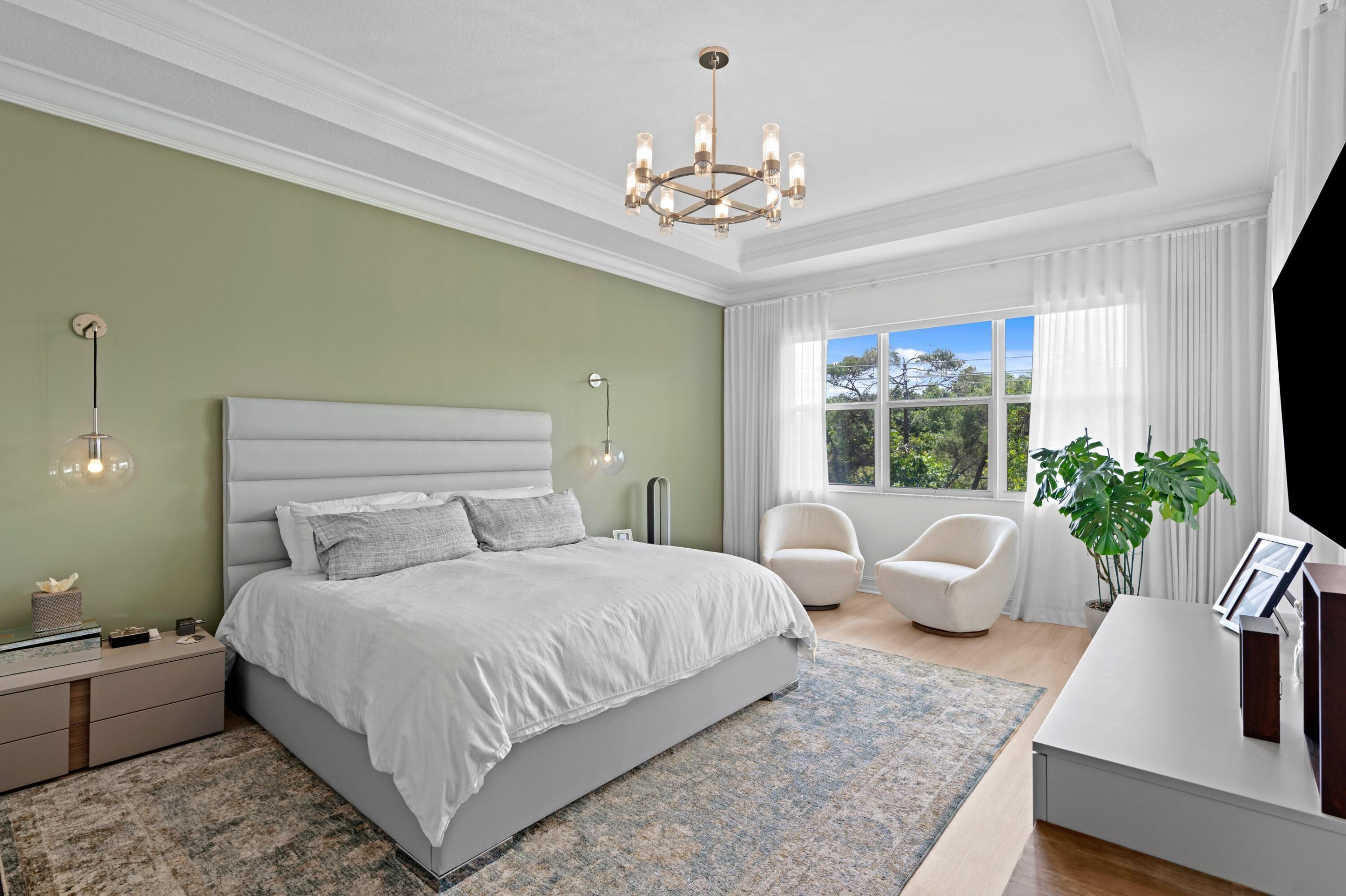 100 Northwest 69th Circle, Unit 82 Boca Raton, FL 33487 - Photo 11 of 42 a bedroom with a large bed and a chandelier