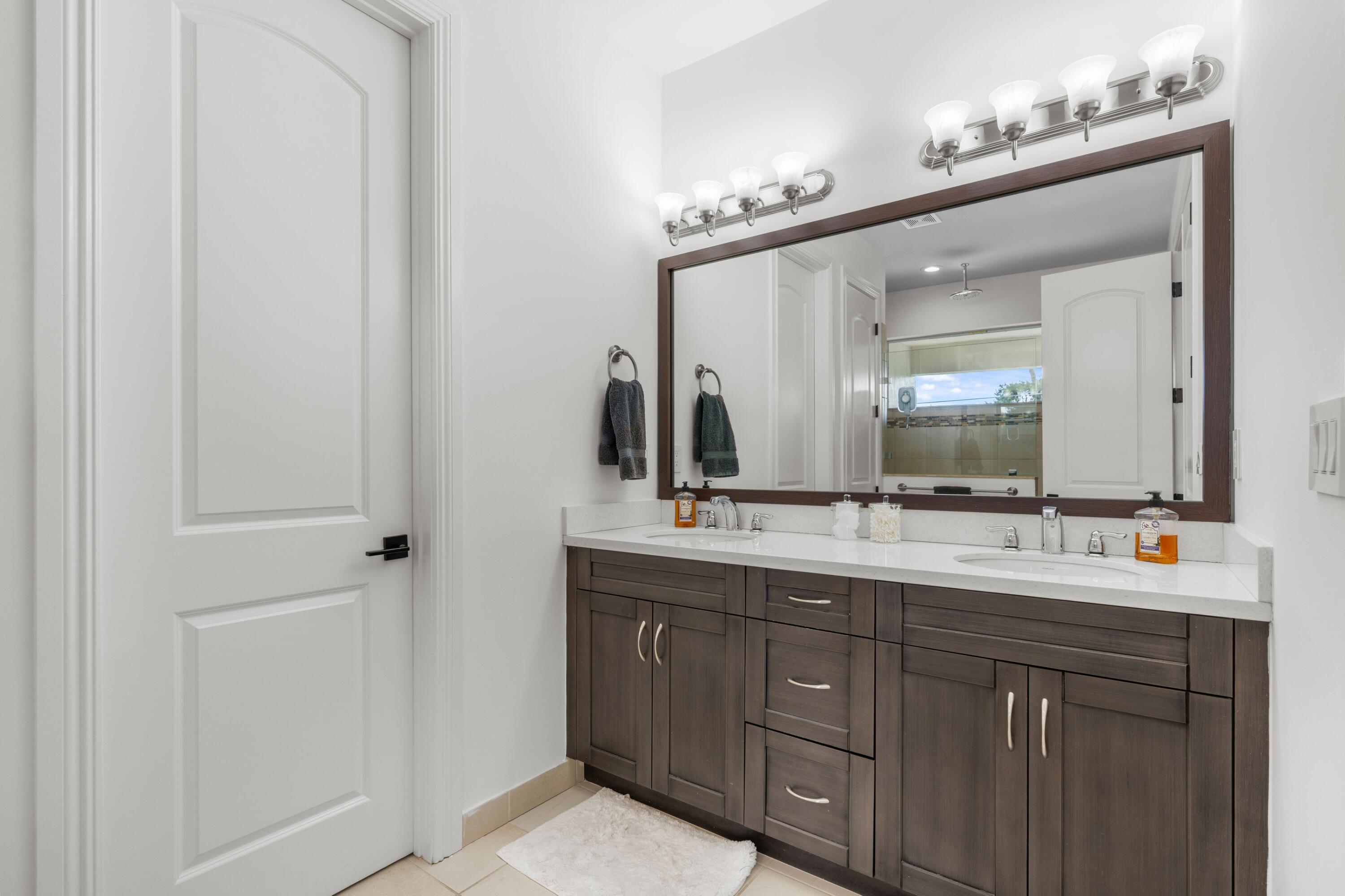 100 Northwest 69th Circle, Unit 82 Boca Raton, FL 33487 - Photo 13 of 42 a bathroom with a double vanity sink and a mirror