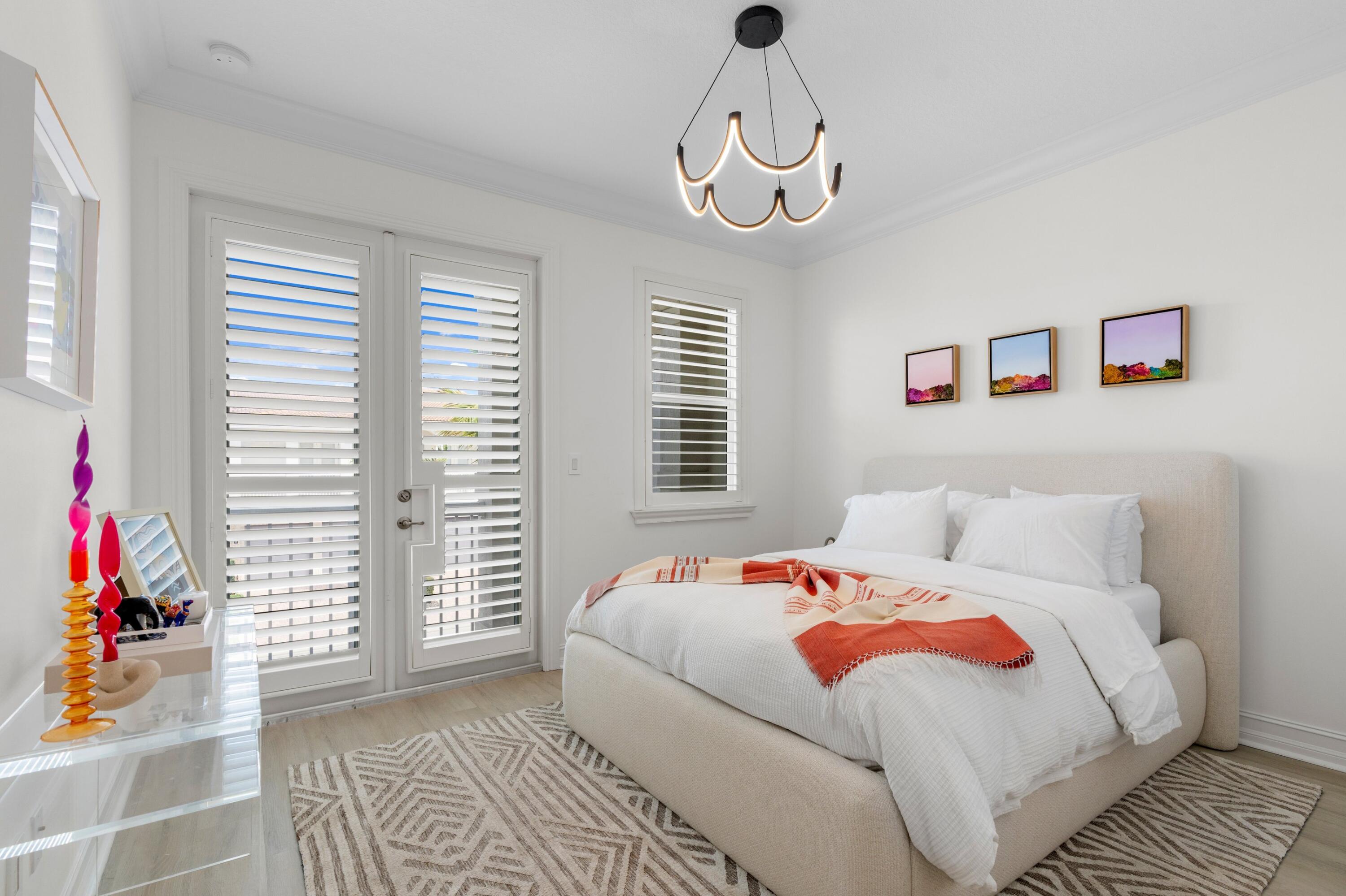 100 Northwest 69th Circle, Unit 82 Boca Raton, FL 33487 - Photo 16 of 42 a bedroom with bed and a chandelier