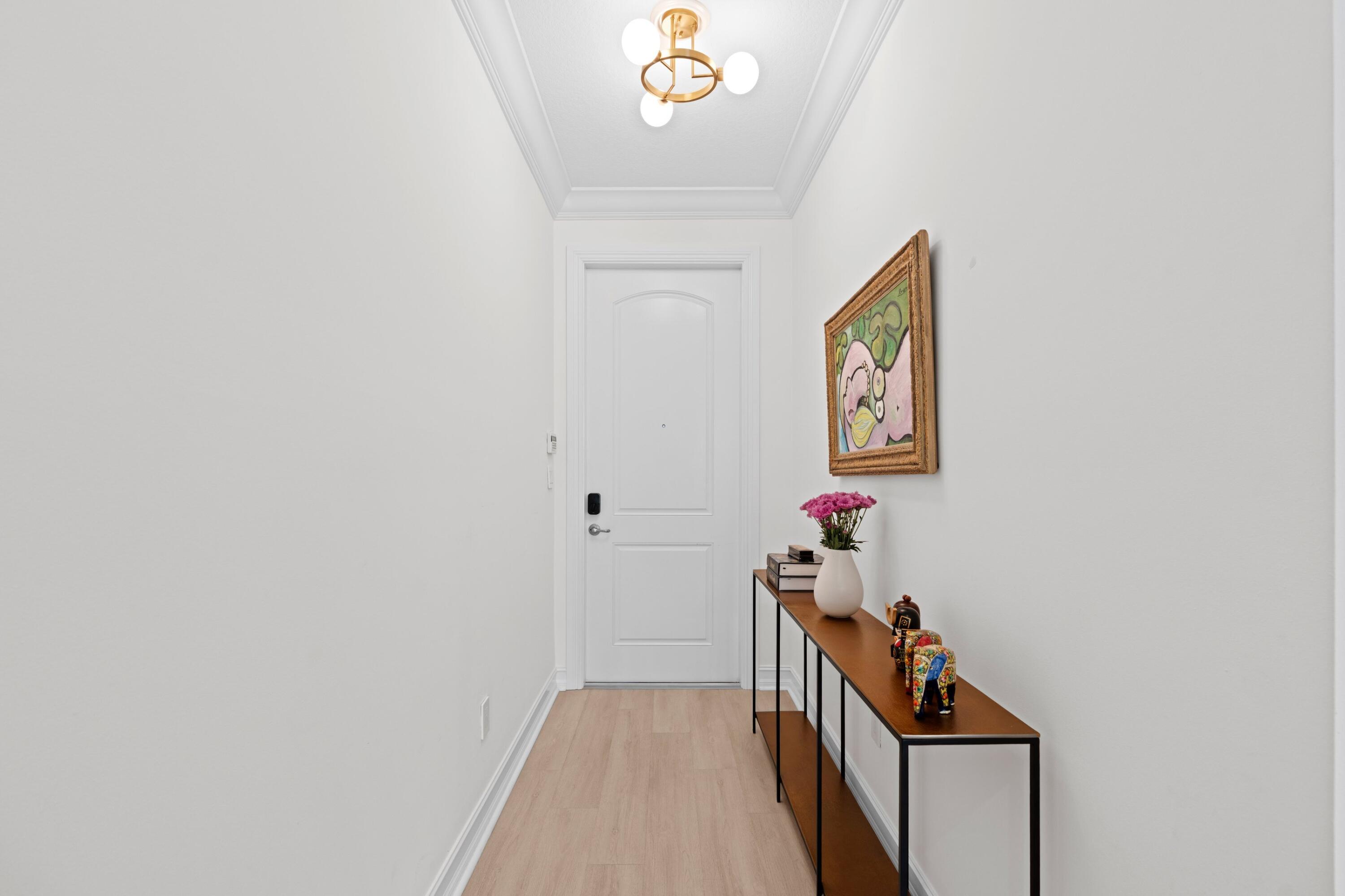 100 Northwest 69th Circle, Unit 82 Boca Raton, FL 33487 - Photo 21 of 42 a view of a hallway to a livingroom with wooden floor