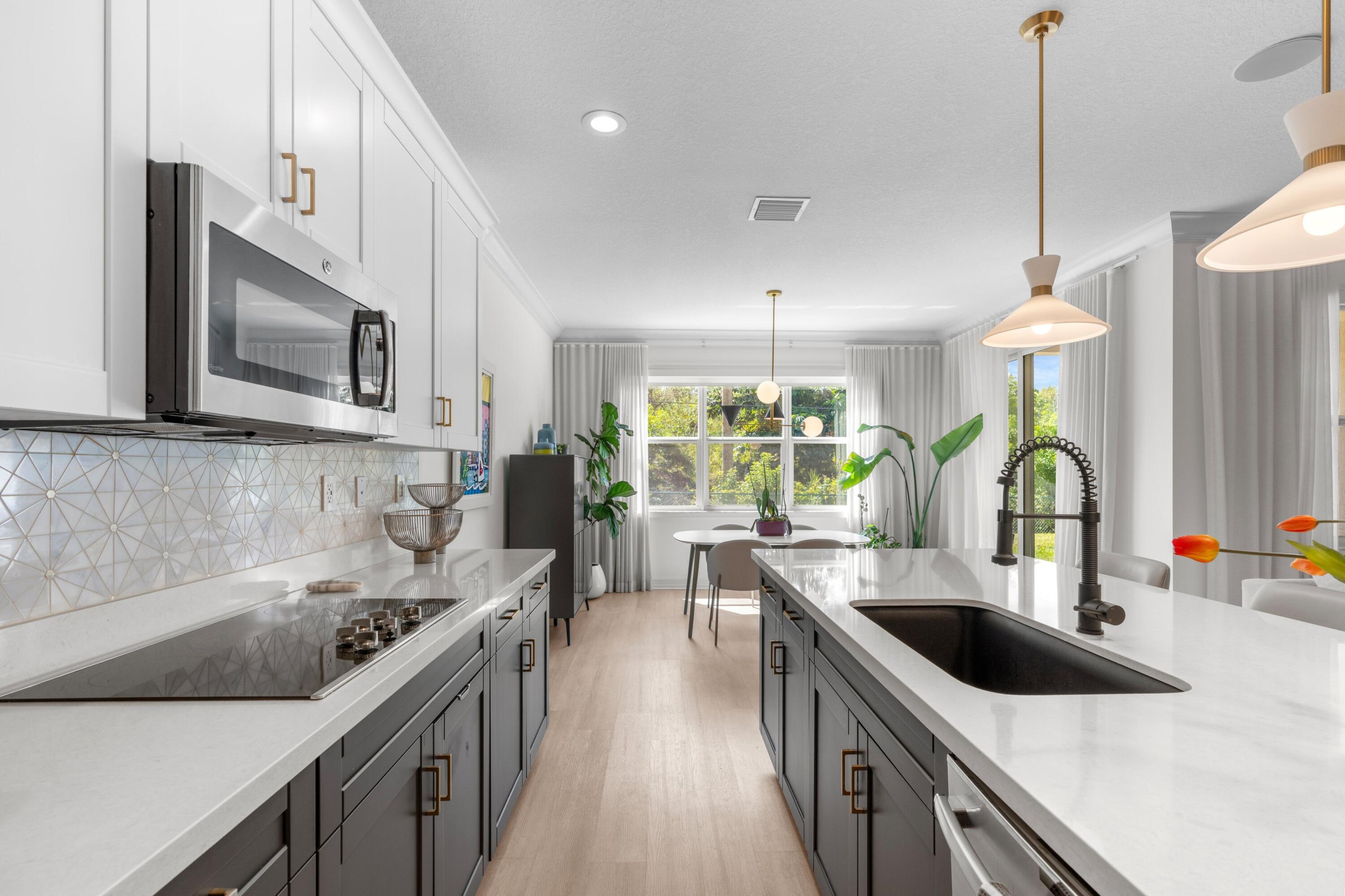 100 Northwest 69th Circle, Unit 82 Boca Raton, FL 33487 - Photo 7 of 42 a kitchen with stainless steel appliances granite countertop a sink a stove and a wooden floors