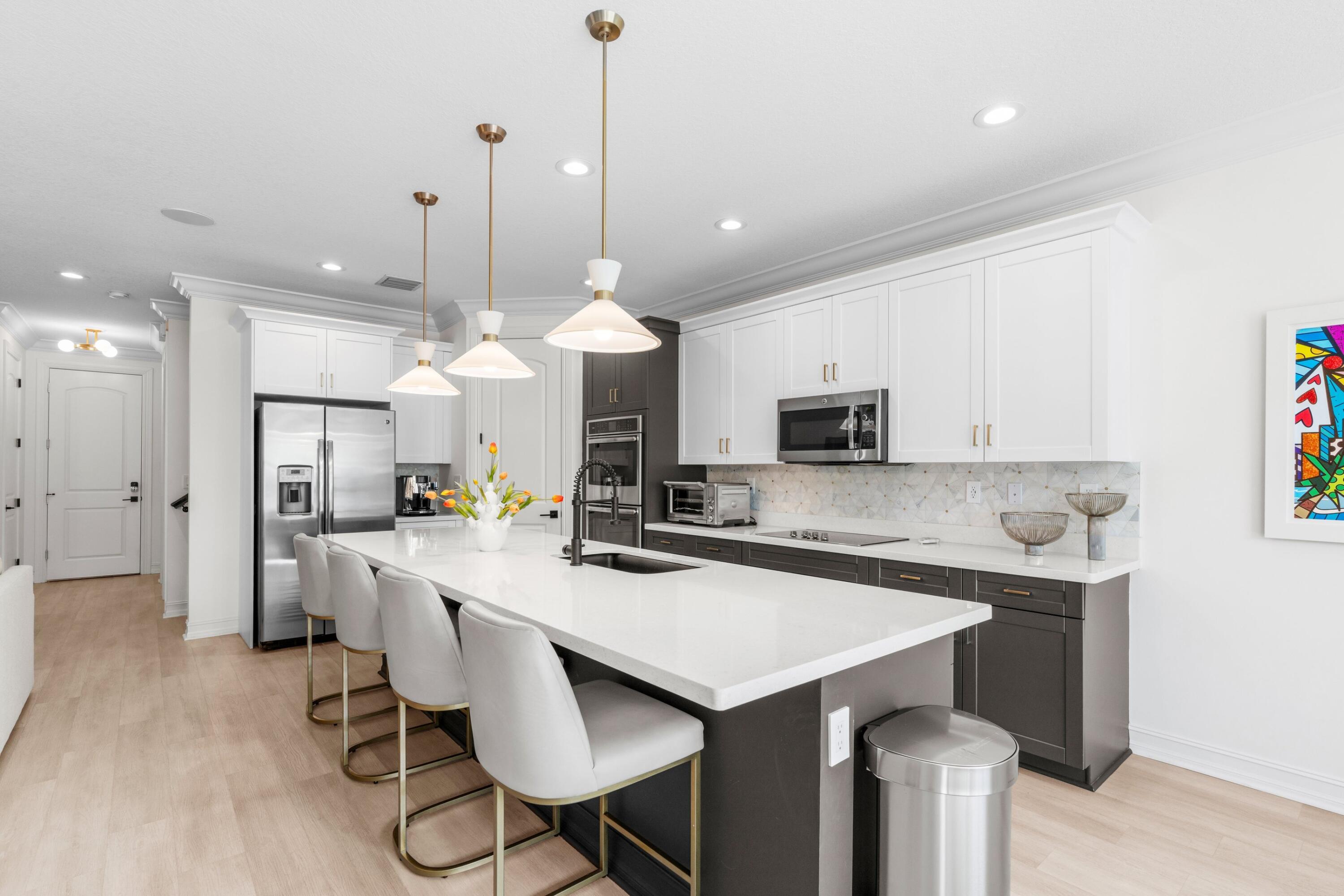 100 Northwest 69th Circle, Unit 82 Boca Raton, FL 33487 - Photo 10 of 42 a kitchen with stainless steel appliances kitchen island granite countertop a sink a stove a refrigerator and island with wooden floor