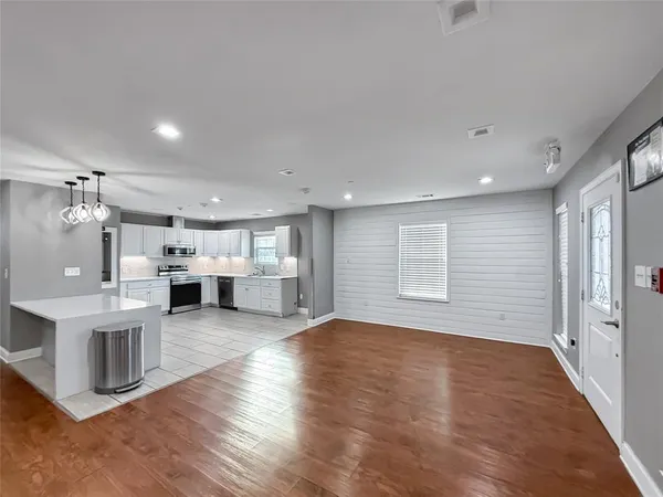 a view of a kitchen with furniture and wooden floor