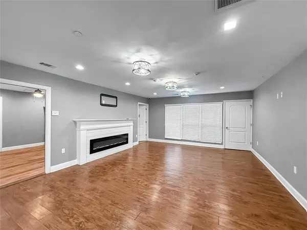 a view of an empty room with a fireplace and a window