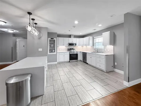 a large kitchen with kitchen island a sink stainless steel appliances and cabinets