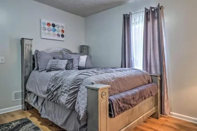 a bed sitting in a bedroom next to a window