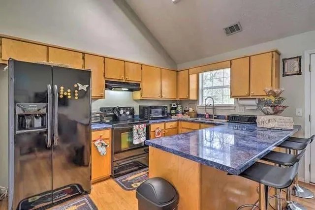 a kitchen with stainless steel appliances granite countertop a stove a sink and a refrigerator