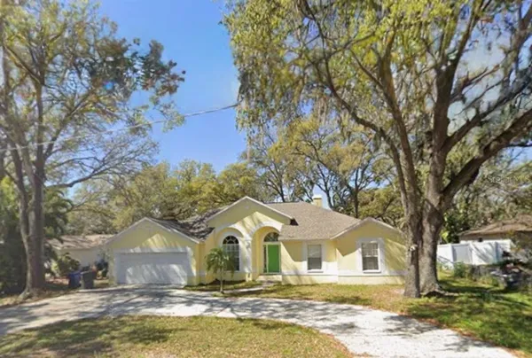 a front view of a house with a yard covered with snow