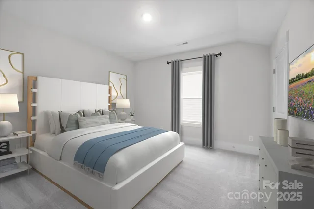 a bedroom with a large bed and a flat tv screen on dresser