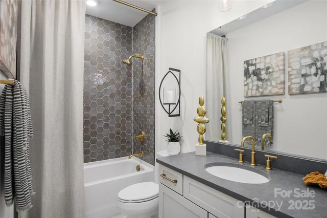 a bathroom with a granite countertop sink a toilet a mirror and shower
