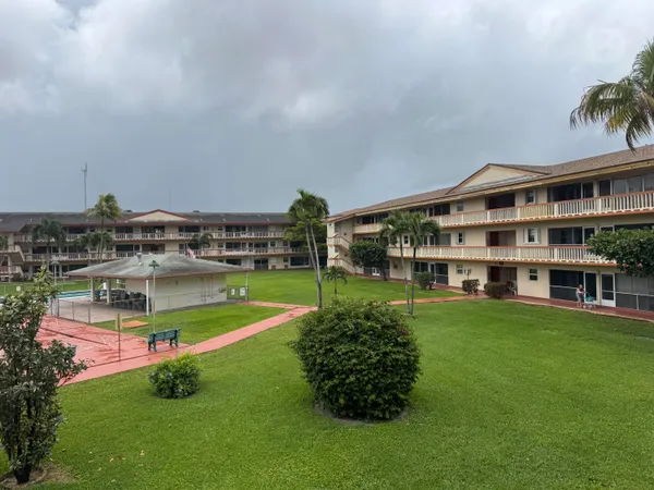 a view of a house with a big yard and sitting area