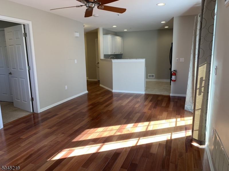 a view of a kitchen with wooden floor and a window