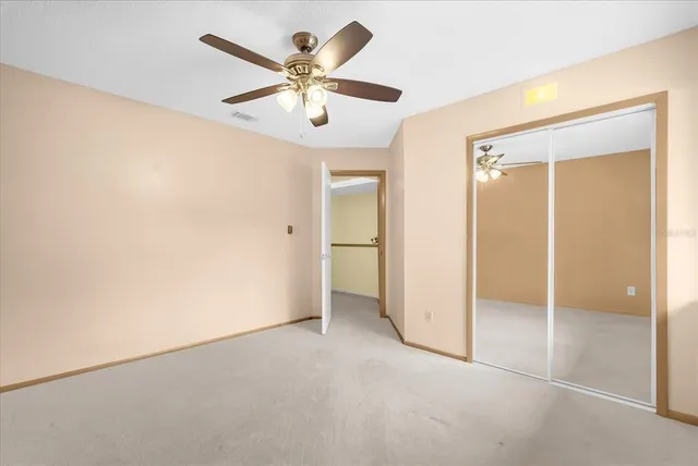 an empty room with a ceiling fan and a window
