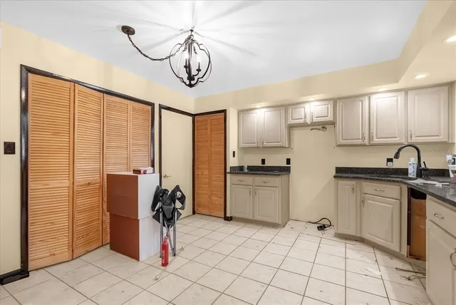 a kitchen with a refrigerator and white cabinets