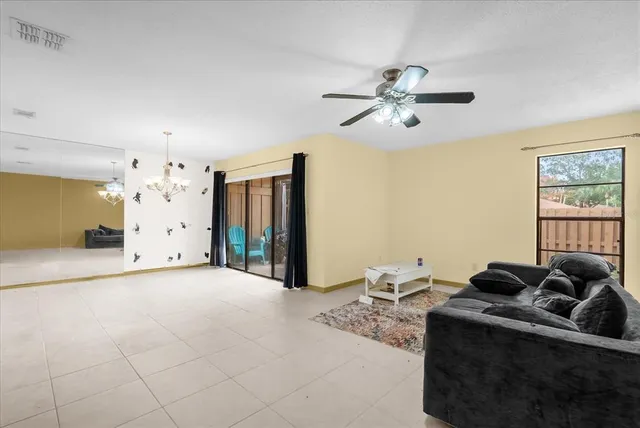 a living room with hard wood flooring furniture and a chandelier