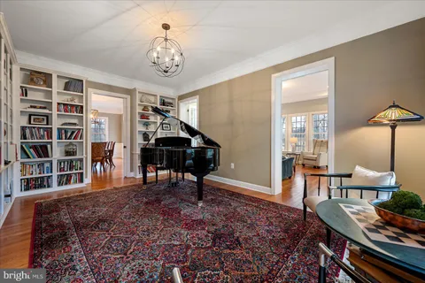 a view of a hallway with windows and chandelier