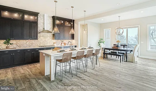 a kitchen with a dining table chairs cabinets and stainless steel appliances